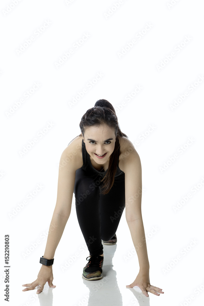 Female runner in ready position to run Female runner in ready position to run