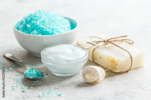 Home cosmetic with cream and blue sea salt on stone background