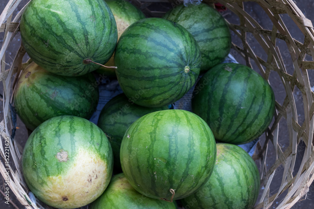 Many big sweet green watermelons sell on an organic food market Sukawati, tropical island Bali, Indonesia.