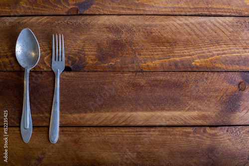 Fork, spoon, knife on the wooden table background with copy place. Concept kitchen and restaurant service. Top view.