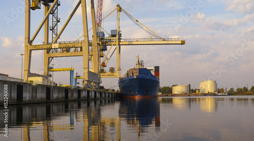 Bulk carrier moored at the quay, and busy with cargo operations.Commercial port in Szczecin, Poland