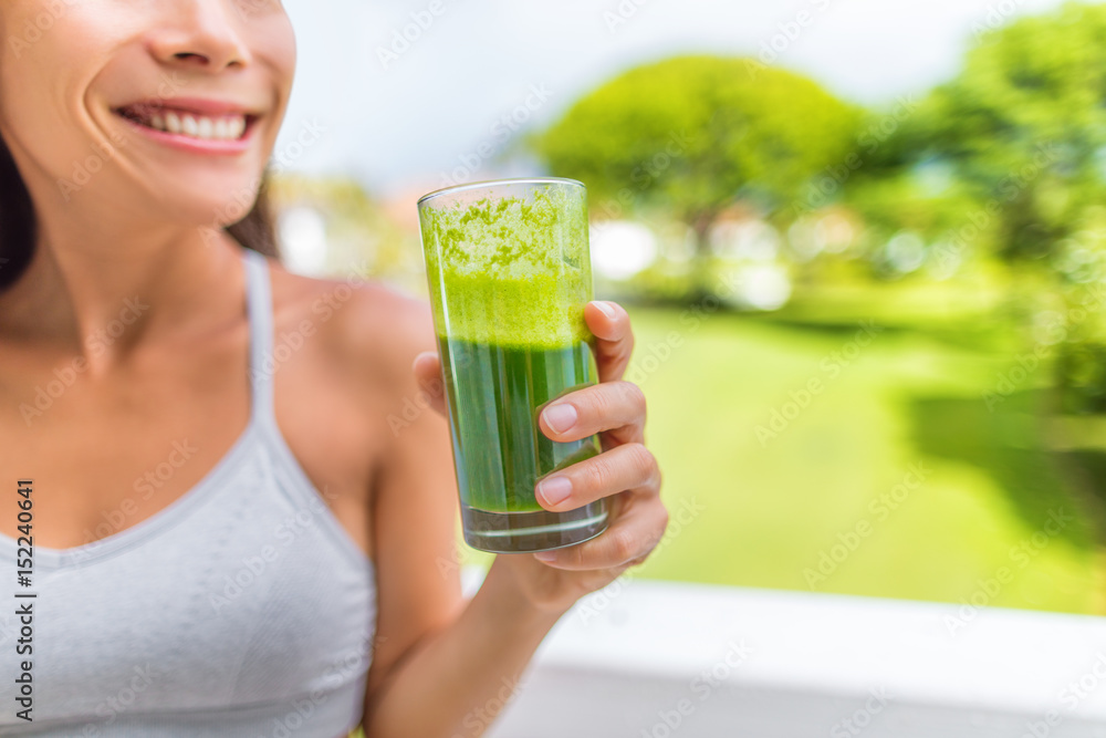Green smoothie healthy lifestyle fitness woman drinking spinach juice cleanse in summer background at home. Happy fit girl living active life juicing. Green smoothie healthy lifestyle fitness woman drinking spinach juice cleanse in summer background at home. Happy fit girl living active life juicing.