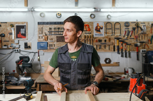 Young professional carpenter working in the workshop