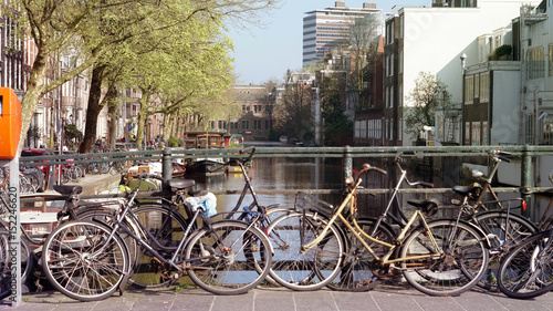 Green tranportation of Amsterdam, Netherland. Bikes parking over canal bridge photo