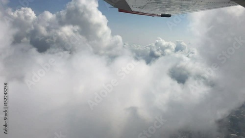 aerial view under wings of  cloud ceiling over tropical bay 