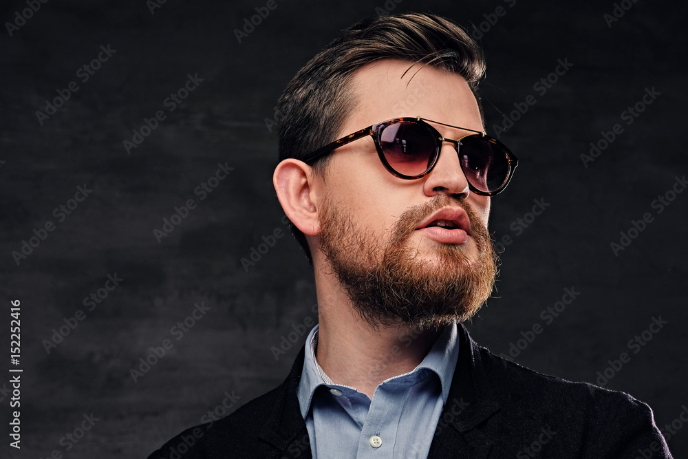An elegant bearded male dressed in cotton velvet suit and sunglasses. An elegant bearded male dressed in cotton velvet suit and sunglasses.