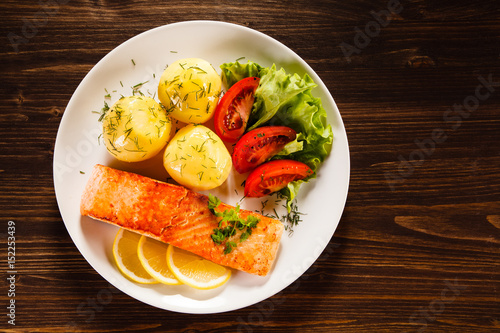 Grilled salmon with potatoes on wooden table