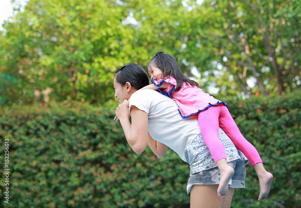 Happy family, Portrait of cute little girl riding on mother back in the park. Happy family, Portrait of cute little girl riding on mother back in the park.