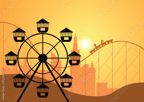 Silhouettes of a city and amusement park with the Ferris wheel .