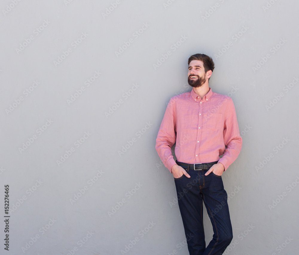 Fototapeta premium happy man standing against gray wall looking away
