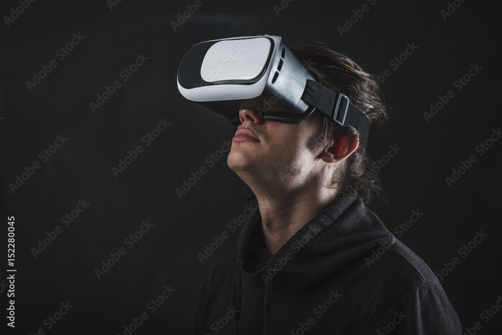man standing in virtual reality helmet before dark background man standing in virtual reality helmet before dark background