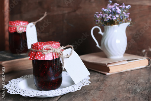 rustic homemade jam jar wooden background and flower