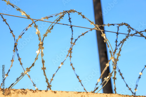 barbed wire fence on the background of clear sky