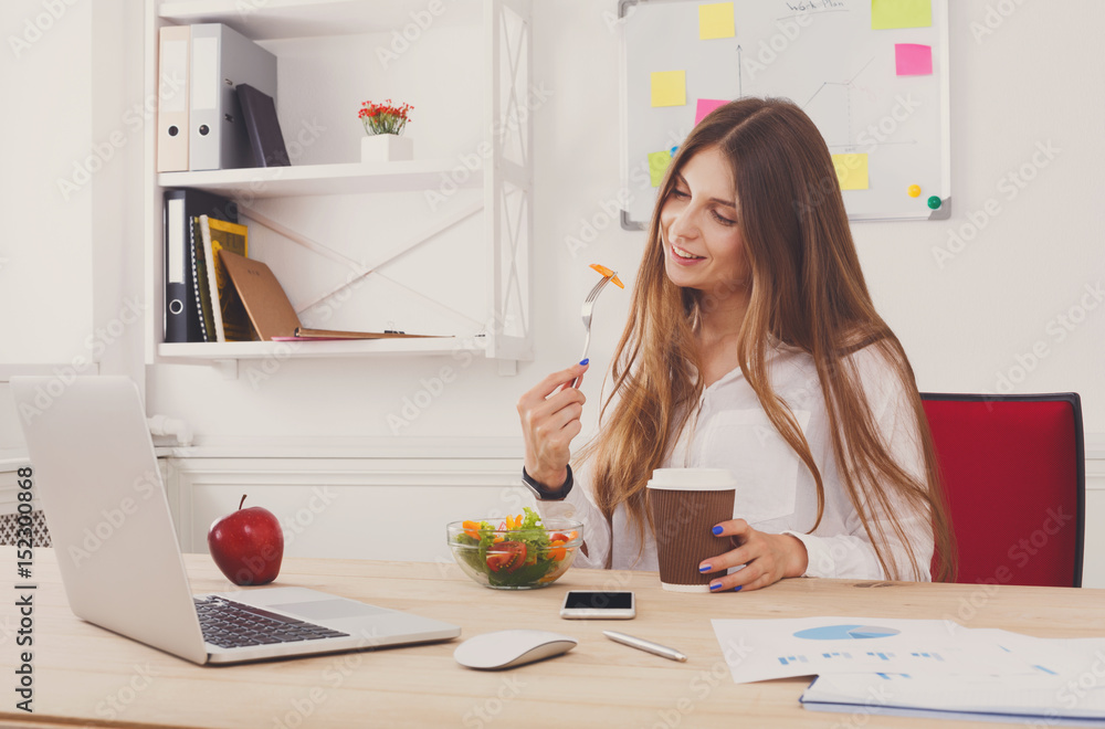 Woman has healthy business lunch in modern office interior Woman has healthy business lunch in modern office interior