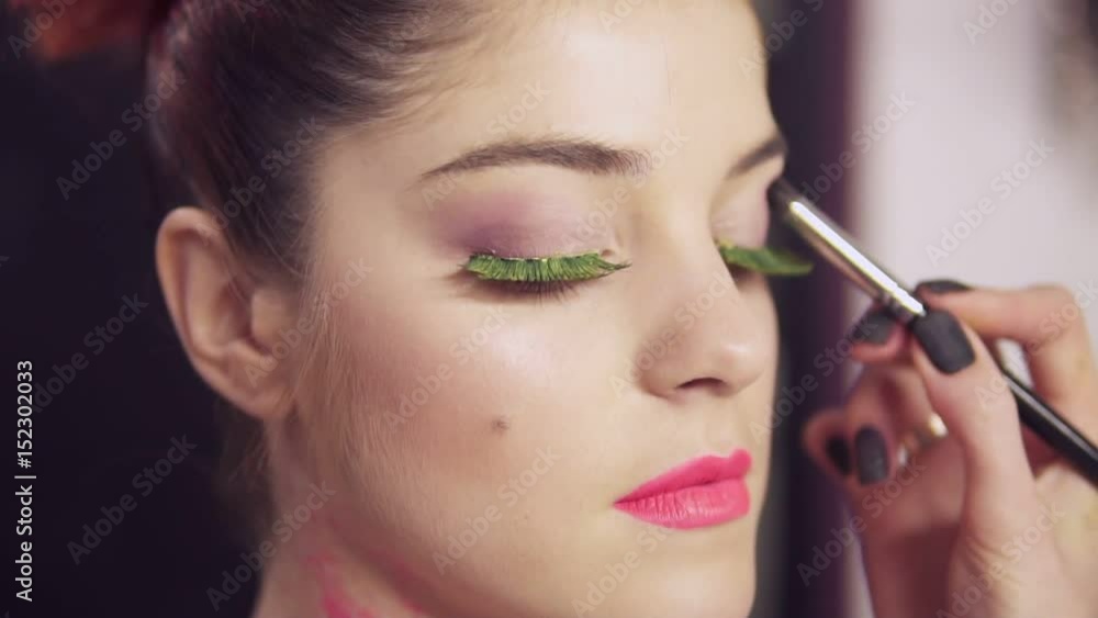Closeup view of makeup artist makes models eye makeup with false eyelashes. Beauty concept Closeup view of makeup artist makes models eye makeup with false eyelashes. Beauty concept