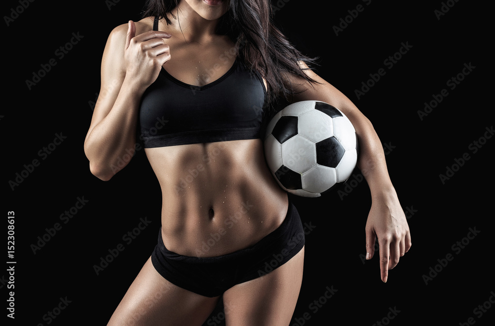 Beautiful body of fitness model holding soccer ball