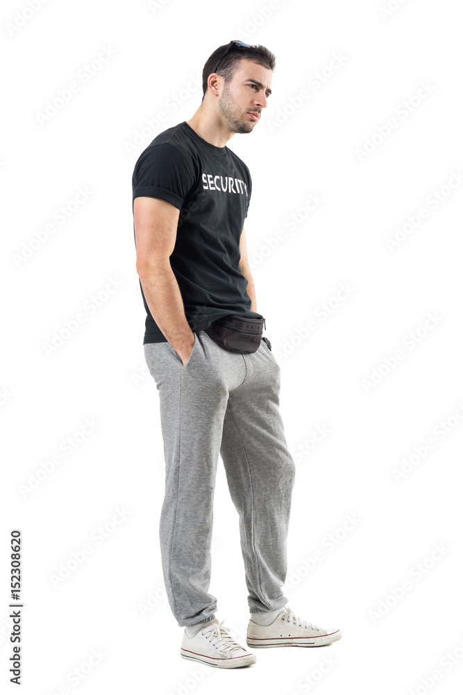Side view of serious doubtful bouncer in sportswear looking at distance. Full body length portrait isolated on white studio background. Side view of serious doubtful bouncer in sportswear looking at distance. Full body length portrait isolated on white studio background.