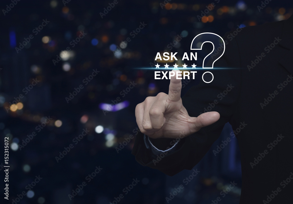 Businessman pressing ask an expert with star and question mark sign icon over blur colorful night light city tower Businessman pressing ask an expert with star and question mark sign icon over blur colorful night light city tower