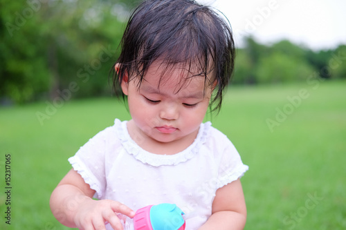 Cute Baby girl playing in the garden, close-up portrait, Portrait of Asian beautiful baby girl of 1 year and 3 months old.