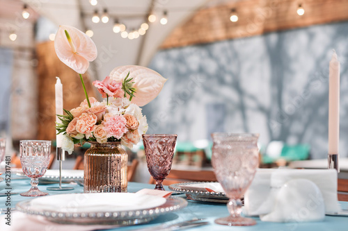 Flower table decorations for holidays and wedding dinner. Table set for holiday, event, party or wedding reception in outdoor restaurant.