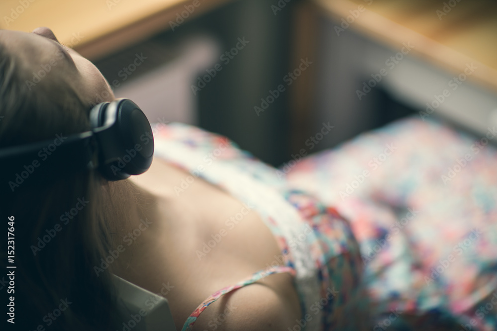 Girl in headphones by the window