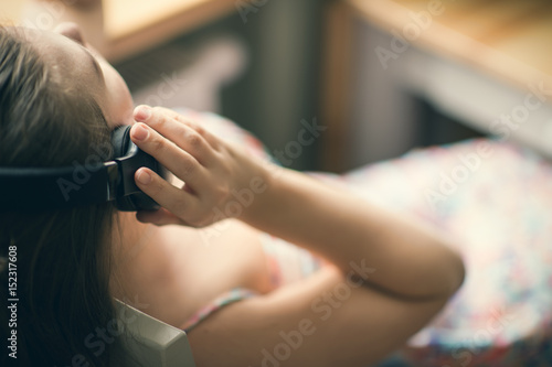 Girl in headphones by the window