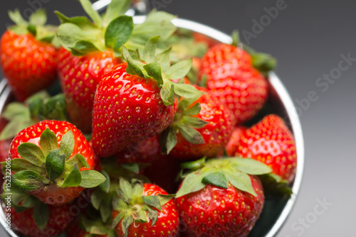 Strawberries in an aluminum bucket on black