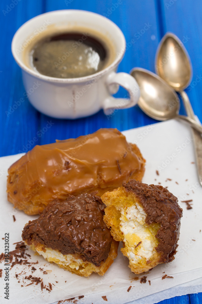 chocolate eclairs on white dish on wooden background chocolate eclairs on white dish on wooden background