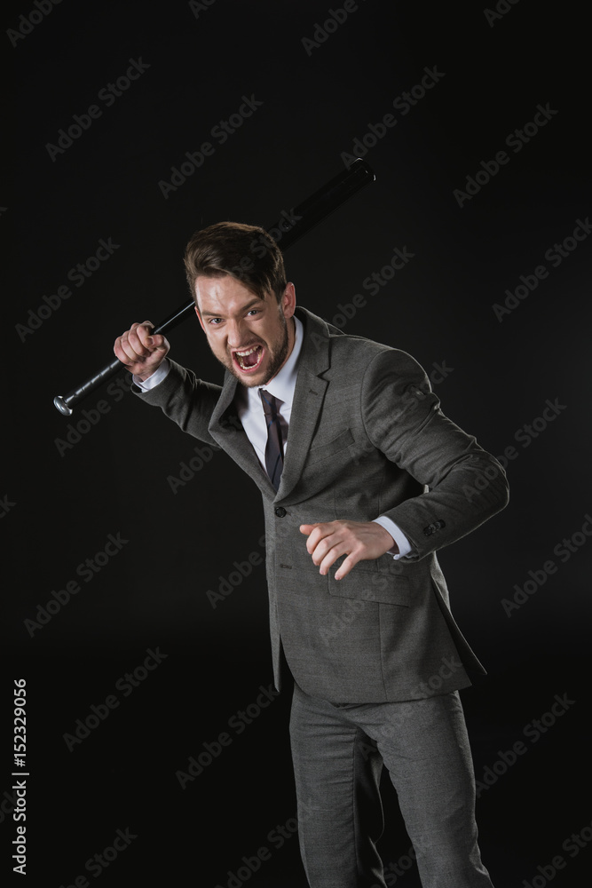 Angry businessman holding baseball bat and screaming isolated on black Angry businessman holding baseball bat and screaming isolated on black