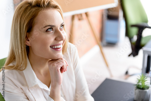 Cheerful girl sitting at her workplace