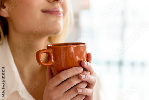 Cheerful girl smiling with hot beverage