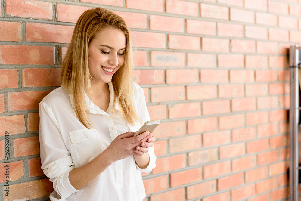 Joyful blonde woman standing with gadget Joyful blonde woman standing with gadget