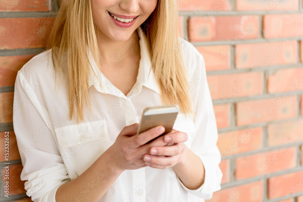 Happy girl standing with smartphone and laughing Happy girl standing with smartphone and laughing