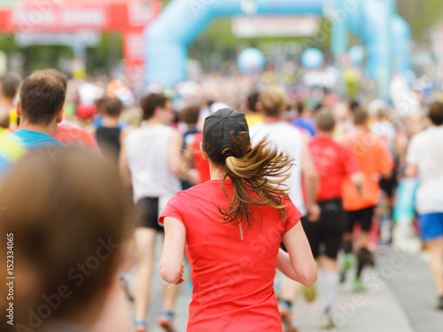 Woman running at marathon at start / finish