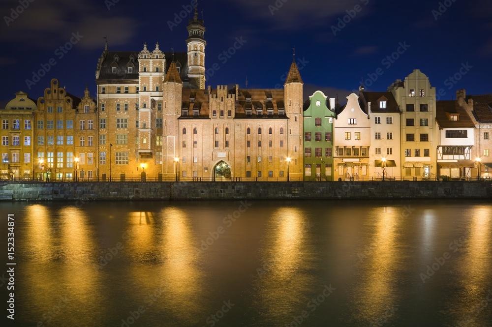 Long Embankment and Motlawa River in the Old Town of Gdansk, Poland at night. Mariacka Gate in the center