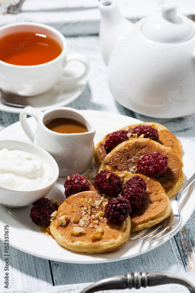 sweet corn pancakes with berries and caramel sauce on white table, vertical sweet corn pancakes with berries and caramel sauce on white table, vertical