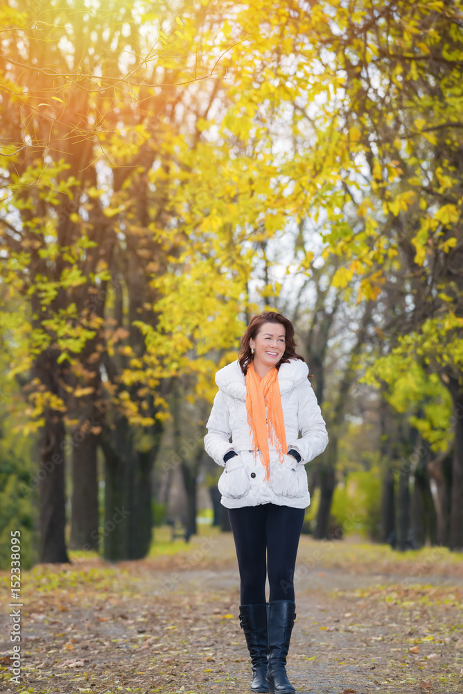 Beautiful woman walking through the autumn park.lens flare Beautiful woman walking through the autumn park.lens flare