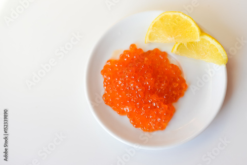 Closeup on red caviar delicacy on white plate, closeup light macro background