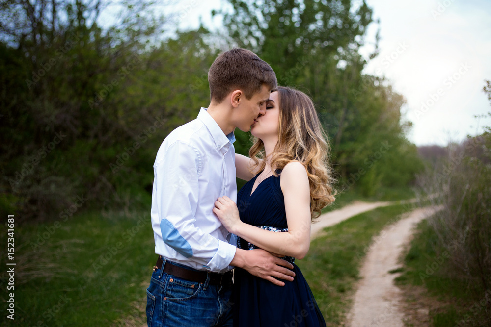 Loving young couple hugging and kissing in the forest Loving young couple hugging and kissing in the forest