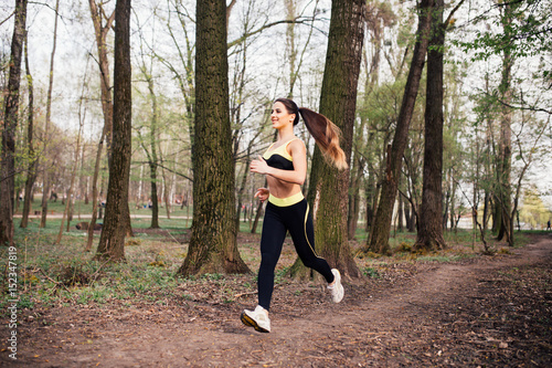 Running woman. Female Runner Jogging during Outdoor Workout in a Park. Beautiful fit Girl. Fitness model outdoors.