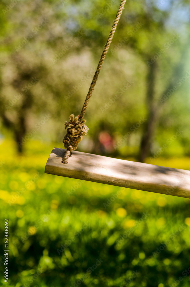 Swing hanged on a tree ,Wooden swing in the garden,wooden swing with green grass background in the park,empty swing Swing hanged on a tree ,Wooden swing in the garden,wooden swing with green grass background in the park,empty swing
