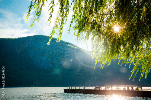 River, mountains and dock with sun shining through the trees from Cold Spring NY photo