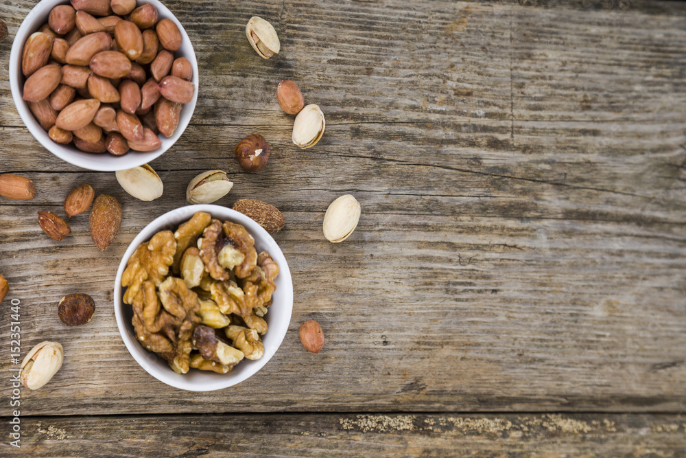 Fototapeta premium Nuts in a plate on a wooden table.