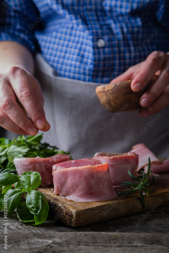 Preparing filet mignon - hands seasoning the steak