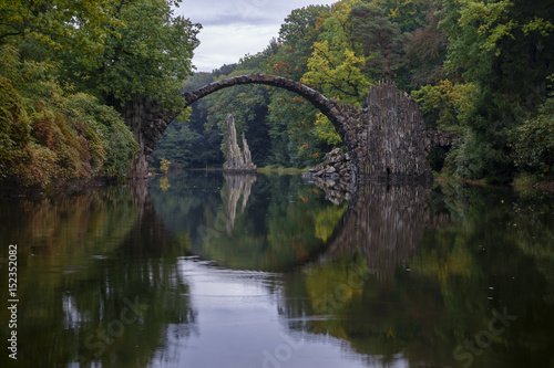 Fototapeta Naklejka Na Ścianę i Meble -  Arch Bridge in Kromlau, Saxony, Germany. Colorful autumn in Germany. Rakotz bridge in Kromlau