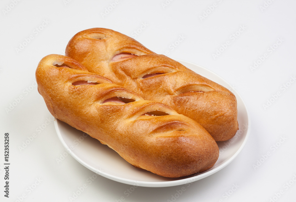 Pancakes roll with sausage on a plate, white background