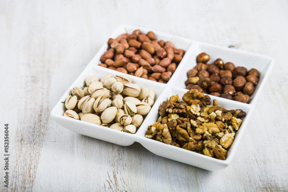 Nuts in a plate on a wooden table. Nuts in a plate on a wooden table.