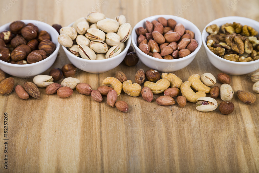 Nuts in a plate on a wooden table Nuts in a plate on a wooden table