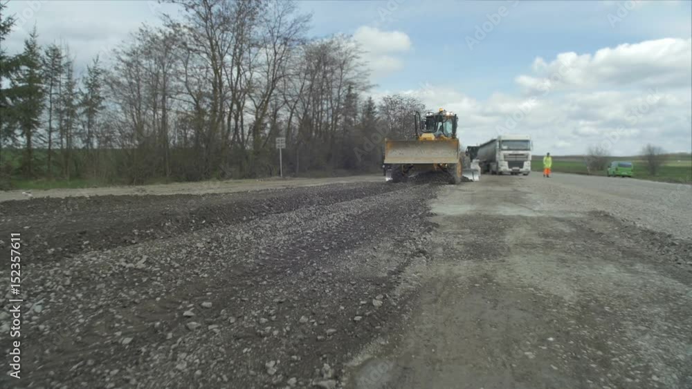 A road crew repairs the road out of the city. A road crew repairs the road out of the city.