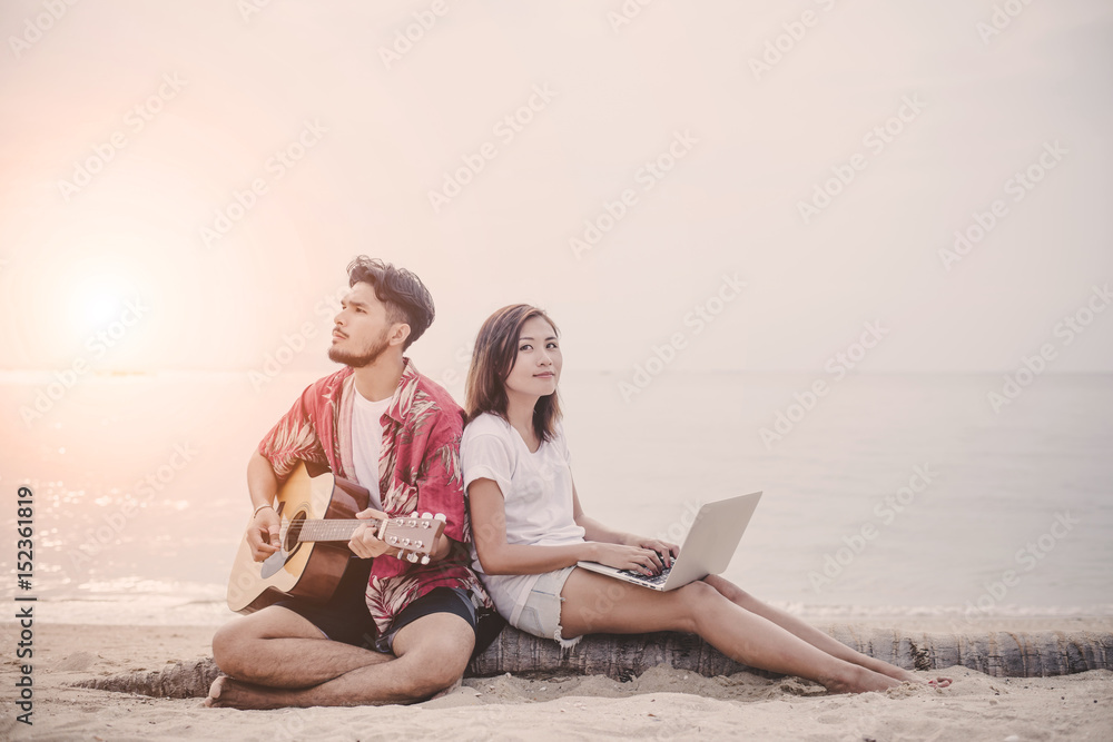 Young couples playing guitar and singing on the beach.